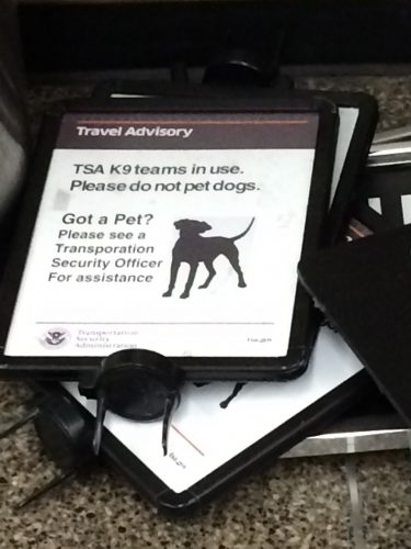 I departed the first security line so promptly that I couldn't get a picture of one of these signs in action on a post; here's an example, though, from a pile waiting for future use. So far, I've only seen them at Seattle's airport.